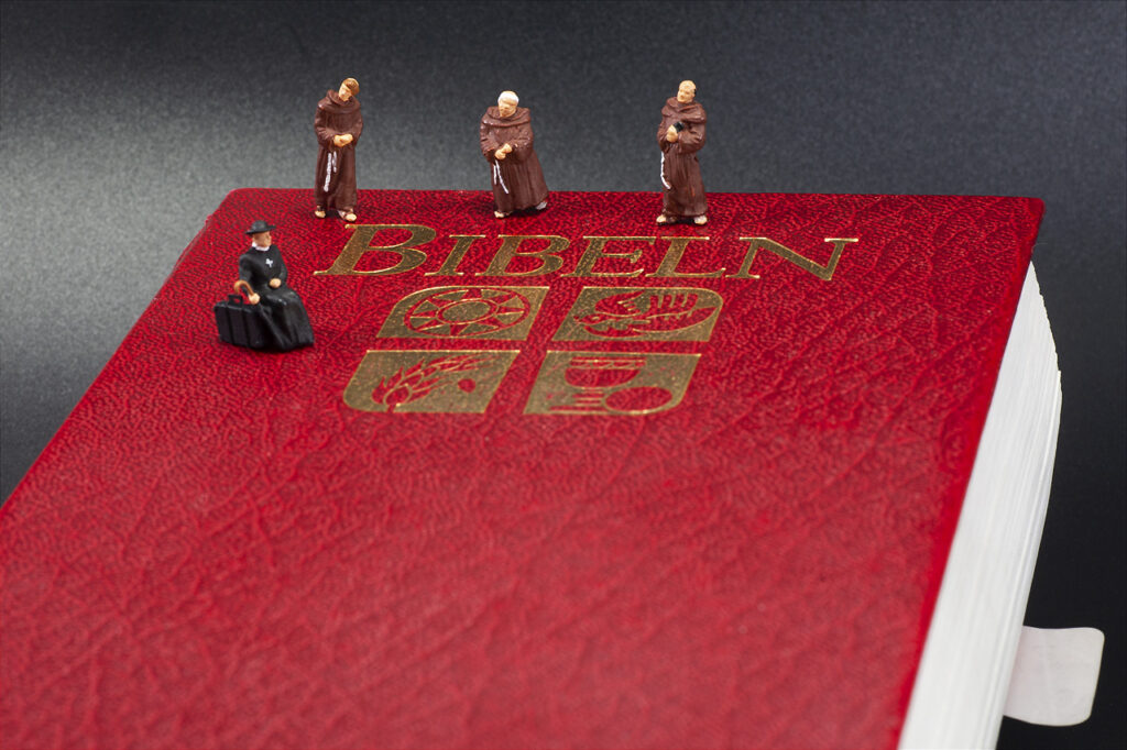 Väntande präst och tre munkar på bibel